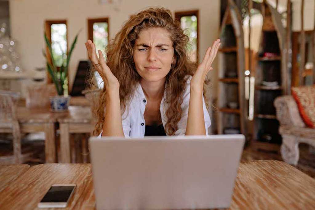 Woman looking frustrated at laptop