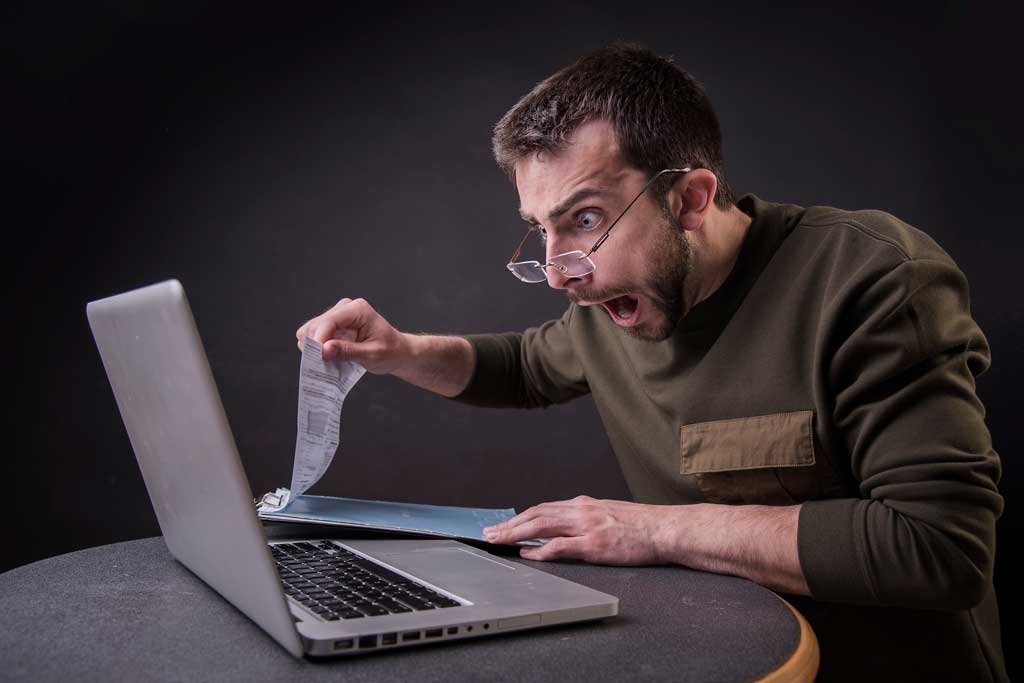 Shocked man looking at laptop